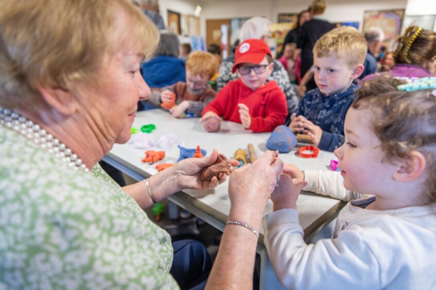 Older woman making play dough with small children