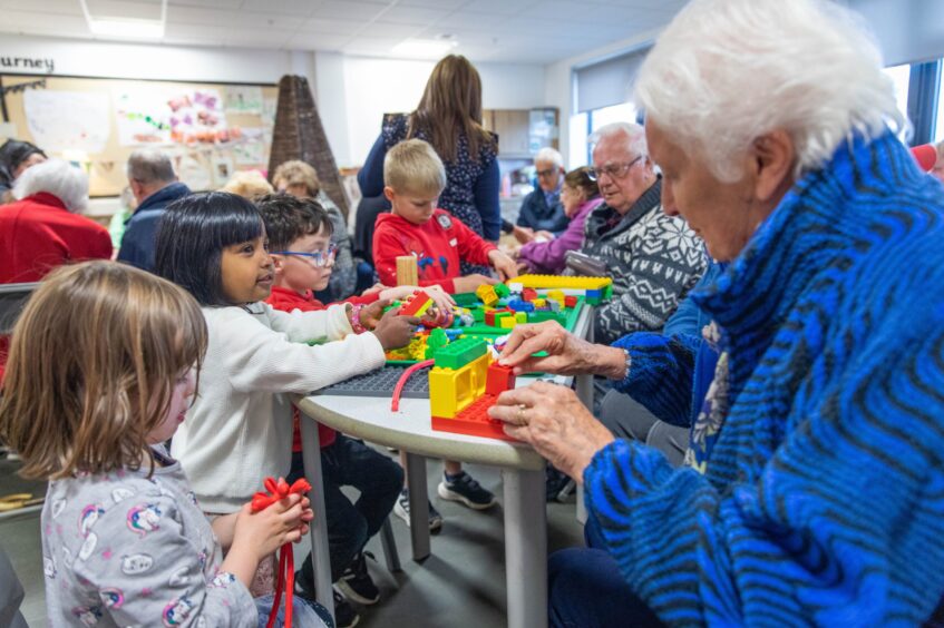 Older people playing with lego with small children