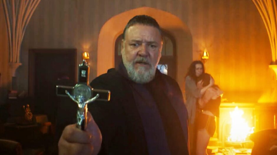 Russell Crowe holds up a crucifix in a scene from The Pope's Exorcist.