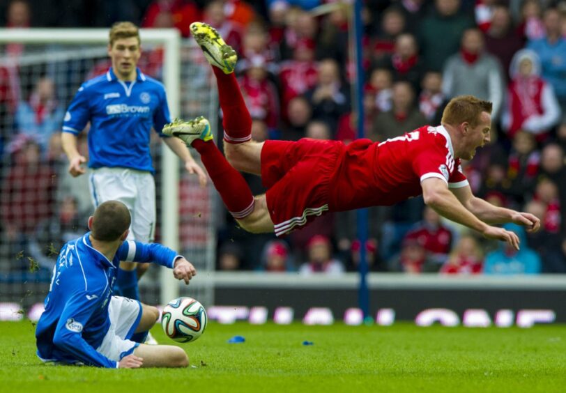 Dave Mackay sends Adam Rooney flying. 