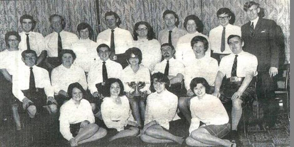 Black and white photo of Aberfeldy and District Gaelic Choir in 1969 at the Aviemore National Mod with Gaelic Tutor, Elizabeth McDiarmid (back row left) and musical conductor, Jimmy Scott (back row right)