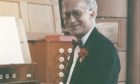 John Walker sitting at organ