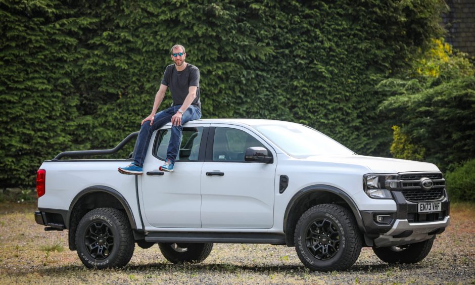 Motoring writer Jack McKeown sits on top of a Ford Ranger