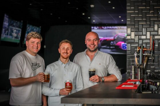 Supervisor Adam Flynn, manager Ian Plenderleith and director Andrew McMahon raise a glass to the opening of Top Dog Sports Bar.