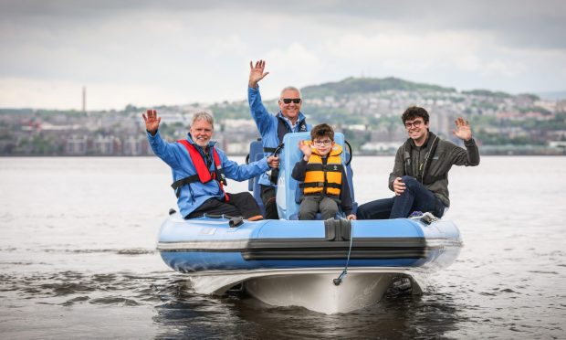 Commodore Ralph Webster, power boat instructor Andrew Lumsden, Archie Dowdell and Alex Middleton from RS Electric Boats on the new boat at Wormit Boating Club. Image: Mhairi Edwards/DC Thomson