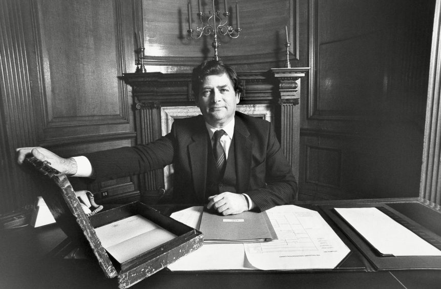 Nigel Lawson, seated at his desk with the famous briefcase, prepares to deliver his budget in 1984. 