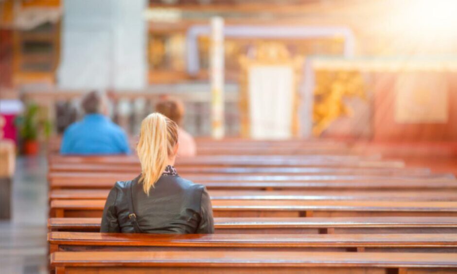 People sit in the pews of a church