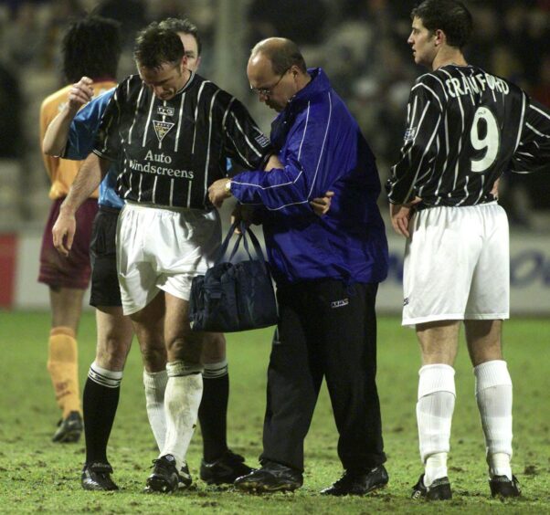 Pip Yeates attends to the injured Ian Ferguson during his spell as Dunfermline physio as Stevie Crawford looks on.