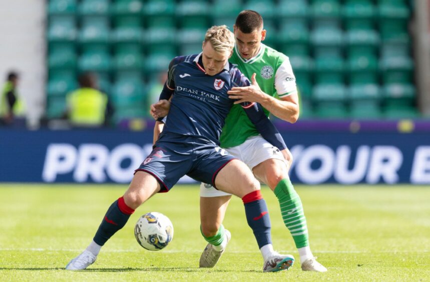 Raith Rovers winger Ethan Ross holds off Hibernian defender Lewis Miller.