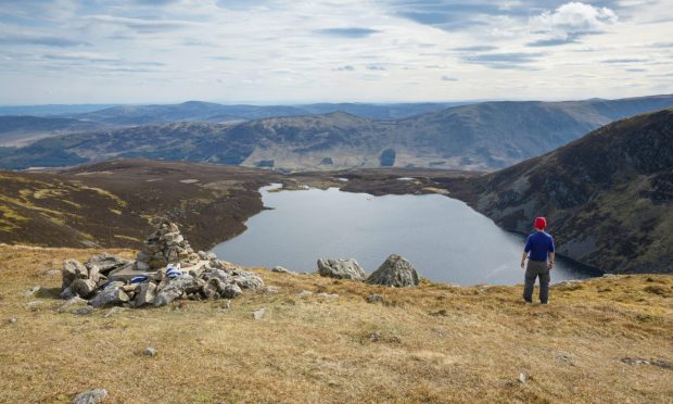 A visitor enjoys the magnificence of Loch Brandy in the Angus glens. Image: VisitScotland