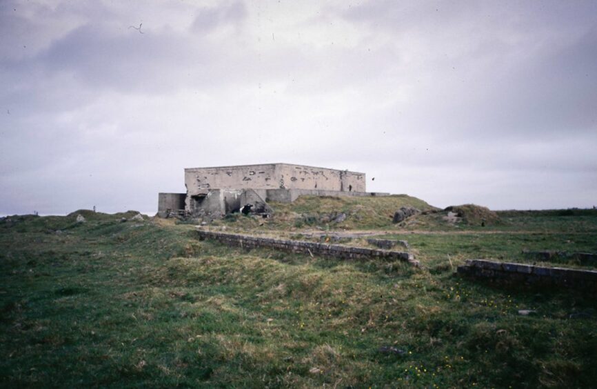 The wartime defences buildings at Douglas Wood set against a grey sky