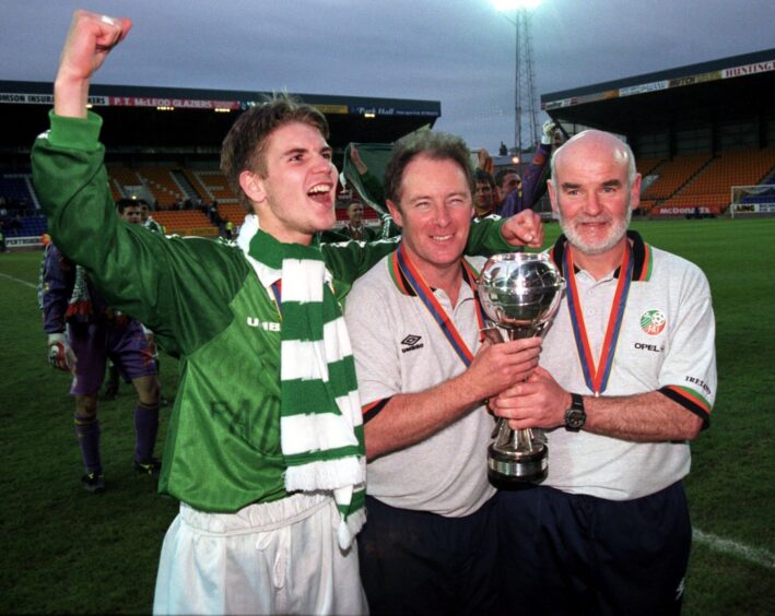 Brian Kerr (centre) and assistant Noel O'Reilly (right) get their hands on the silverware as skipper Sean Byrne celebrates