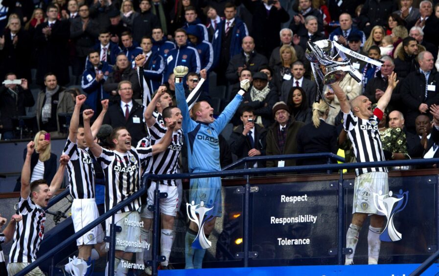 Jim Goodwin holds the League Cup aloft as a youthful John McGinn looks on