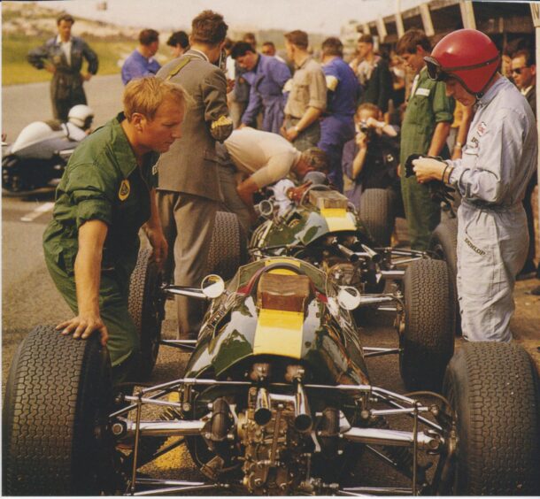 Derek Wild on the left in green overalls, with Lotus F1 driver Peter Arundell on the right. 