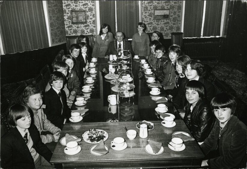 Schoolchildren sit down at a long table to have tea with Lord Provost Harry Vaughan in April 1979.