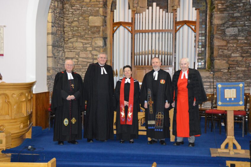 Line up of people in church robes at Ardoch Church, including the Very Rev Dr James Simpson