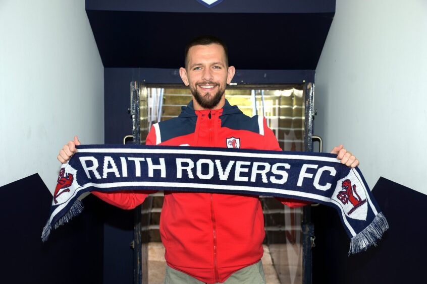 Dylan Easton holds up a Raith Rovers scarf in the Stark's Park tunnel.