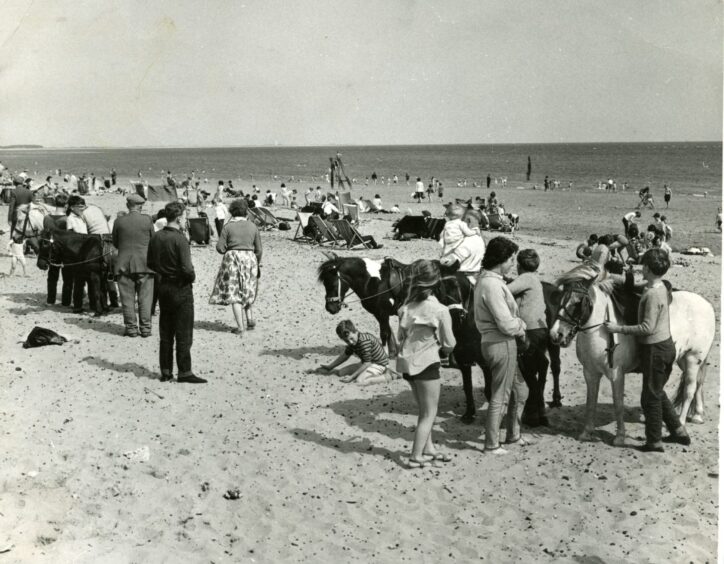 Children line up for donkey rides and people swim in the River Tay at Broughty Ferry beach in July 1964. 