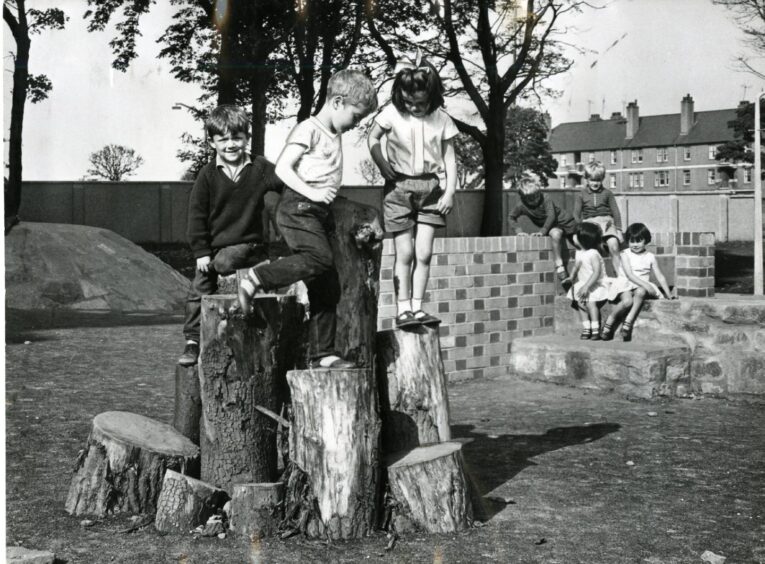 Children enjoying playing on some tree stumps at Foggyley Playpark.