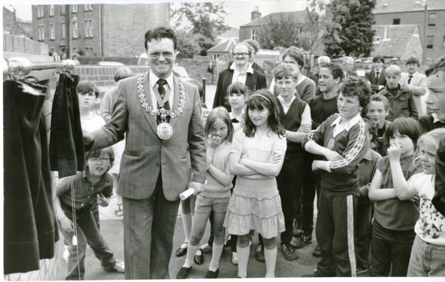 Dundee Lord Provost James Gowans officially opens the Tait's Lane Playpark in July 1983, watched by a crowd of children and adults