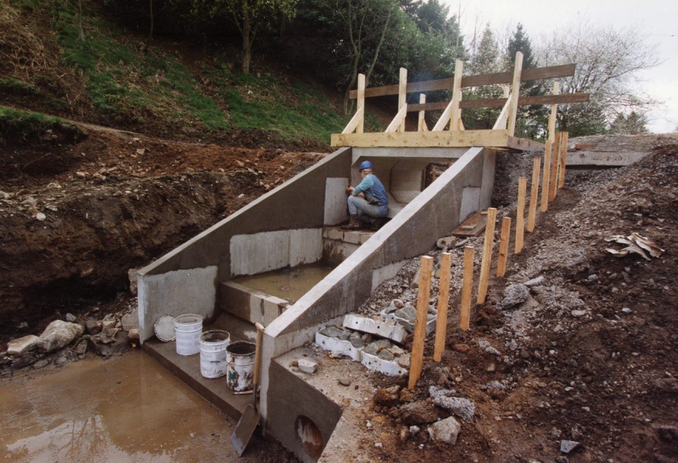 a man at work inside a concrete structure as water steps are put in place at the Den o' Mains upper pond in April 1992.