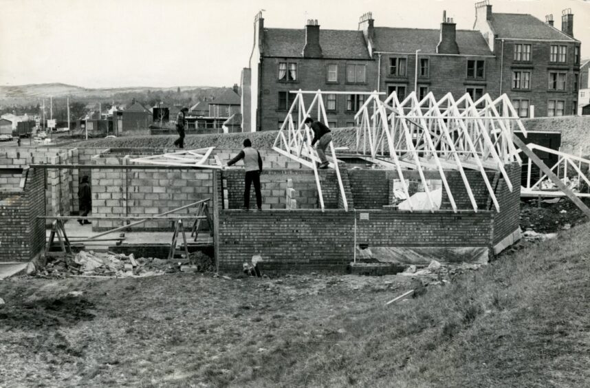 Builders working on the roof of the nascent Lochee police station.