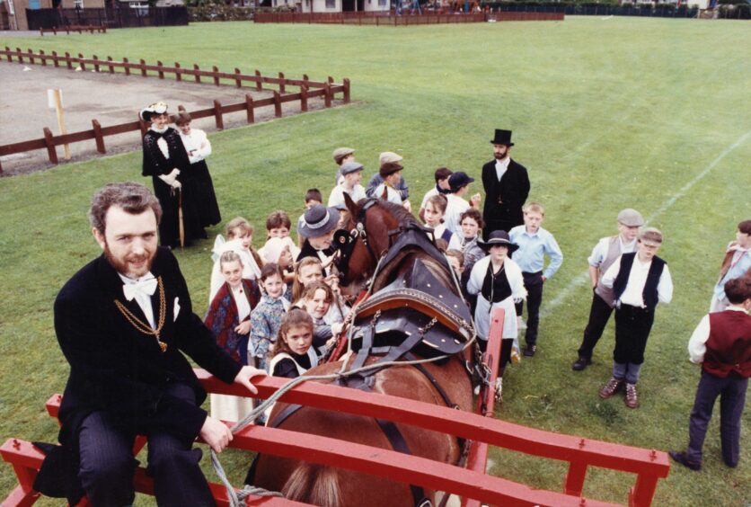 Councillor McDonald on the horse and cart as the pupils look on