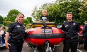 Alfie McLeod (3) on a water rescue boat with firefighter Emma MacKinnon and Crew Commander
John Cooper. Image: Kim Cessford/DC Thomson
