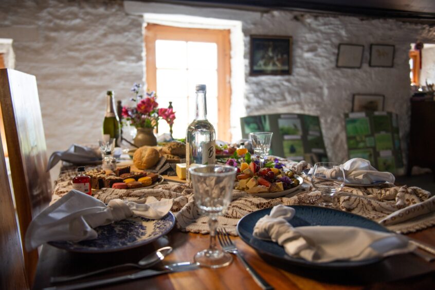 Inside the bothy with the laden picnic table. Image: Kim Cessford.