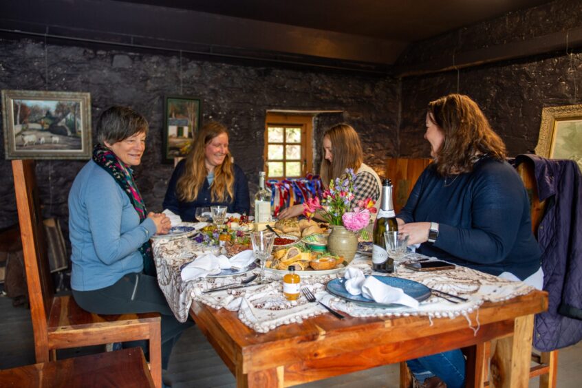 Enjoying a picnic in the cosy bothy at Kinclune. Image: Kim Cessford.