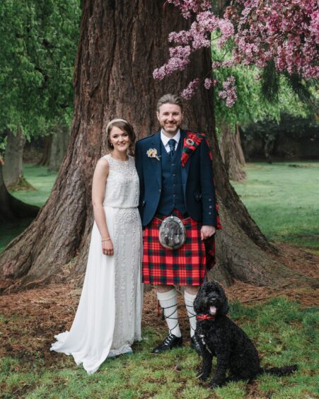 The perfect family unit - Laura and Jamie Fyfe and theit Cockapoo Jasper on their wedding day. Image: Andi Watson Photography.