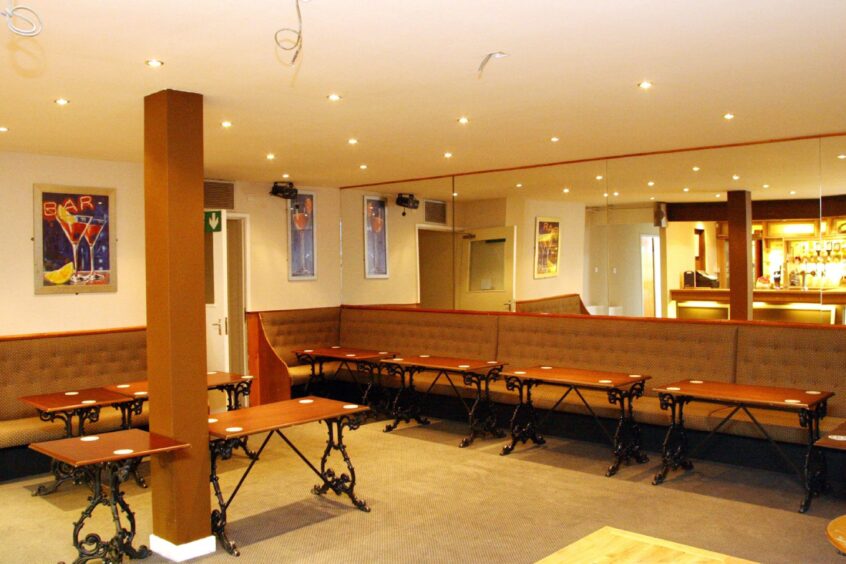 The inside of the pub, with empty tables and chairs