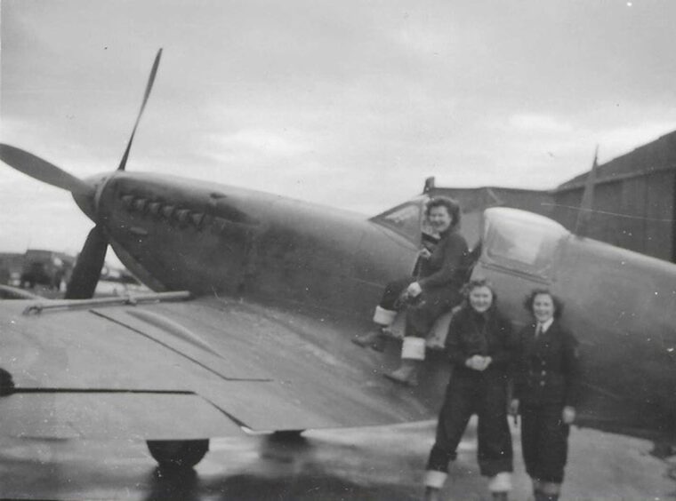 Margaret, centre, stands beside a Seafire - the Naval equivalent of a Spitfire.