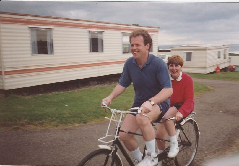 Family snapshot of Martin Reid steering a tandem with Flo Reid behind