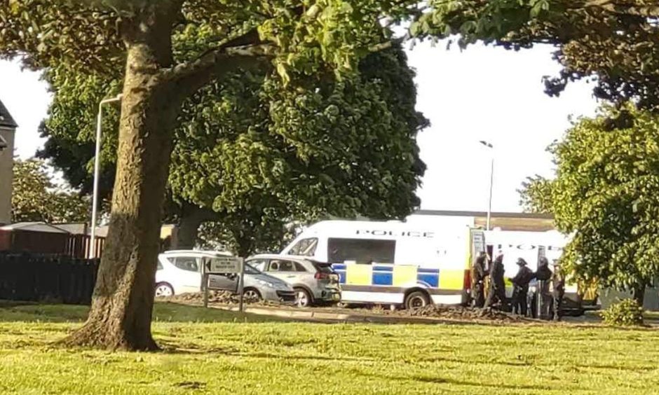 Officers in riot gear at the scene.