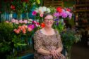 Jillian Page sitting in front of a display of flowers