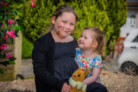 Alyssa MacDonald smiling with her little sister by her side