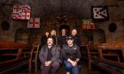 Image shows the Paranormal Investigation team from Haunted Scotland. The six team members are pictured in the grand dining hall at Balgonie Castle. Lisa Sproat, Tracey Whyte, John Whyte and Louise Walker are standing behind Lead Researchers Greg Stewart and Ryan O'Neill in the dark hall.
