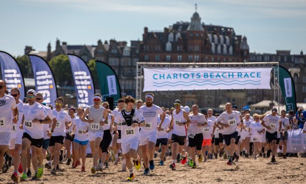An iconic view of St Andrews as the 2024Chariots of Fire beach race gets under way on the West Sands. Image: Steve Brown/DC Thomson