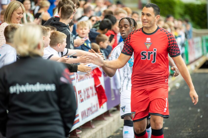 Deniz Mehmet gives young Dunfermline Athletic FC supporters a 'high five'.