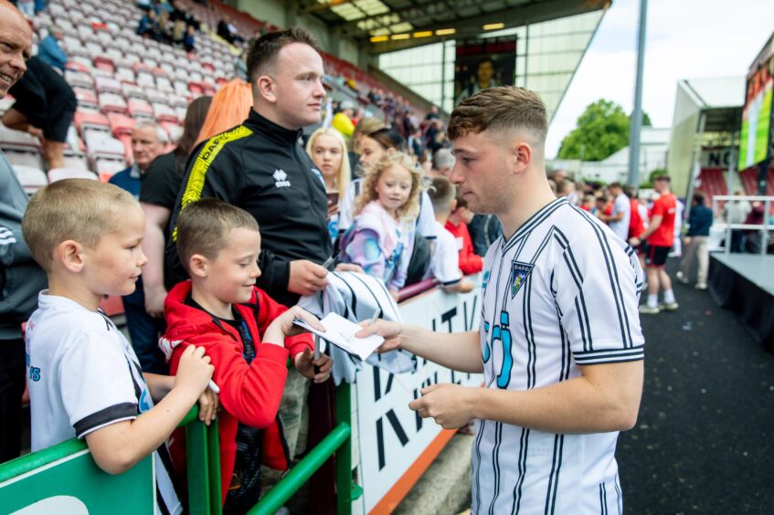 Taylor Sutherland signs autographs for young Dunfermline fans at the club's kit launch.