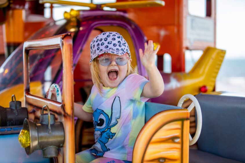 Four-year-old Elidh Hope from Leven waves from the roundabout at the Leven funfair