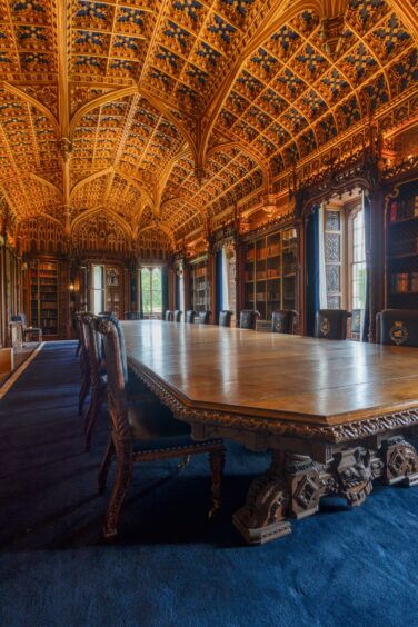 Taymouth Castle library with elaborate wood panelled ceiling and long oak table