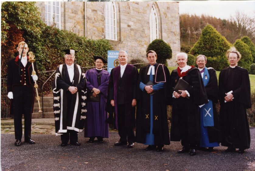 Line up of people in church robes, including the Very Rev Dr James Simpson, outside Kemback Church, Fife.