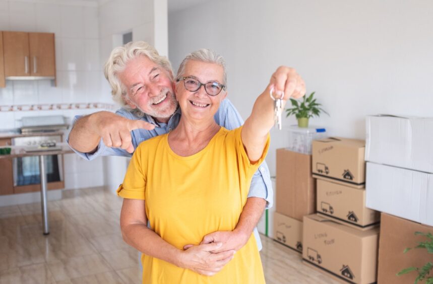 Happy couple with keys in new home. 