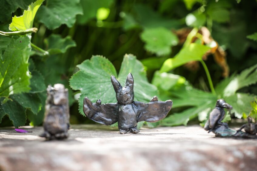 Tiny bronze sculpture of a bat extending its wings