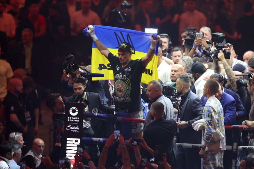 Oleksandr Usyk celebrates unifying the heavyweight world titles.