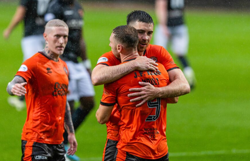 Declan Gallagher embraces another experienced Dundee United pro, Louis Moult.