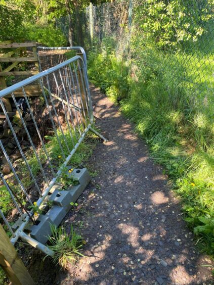 Buckie Braes Path with metal railing and large chunks of path missing