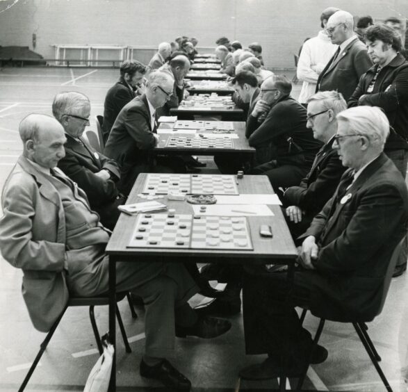 A row of tables as players play checkers